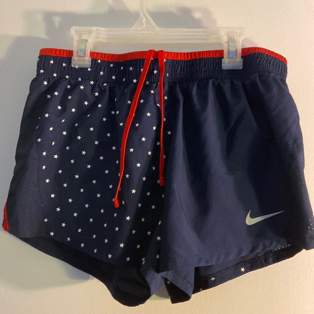 Nike navy blue athletic shorts with white star pattern, red inside.